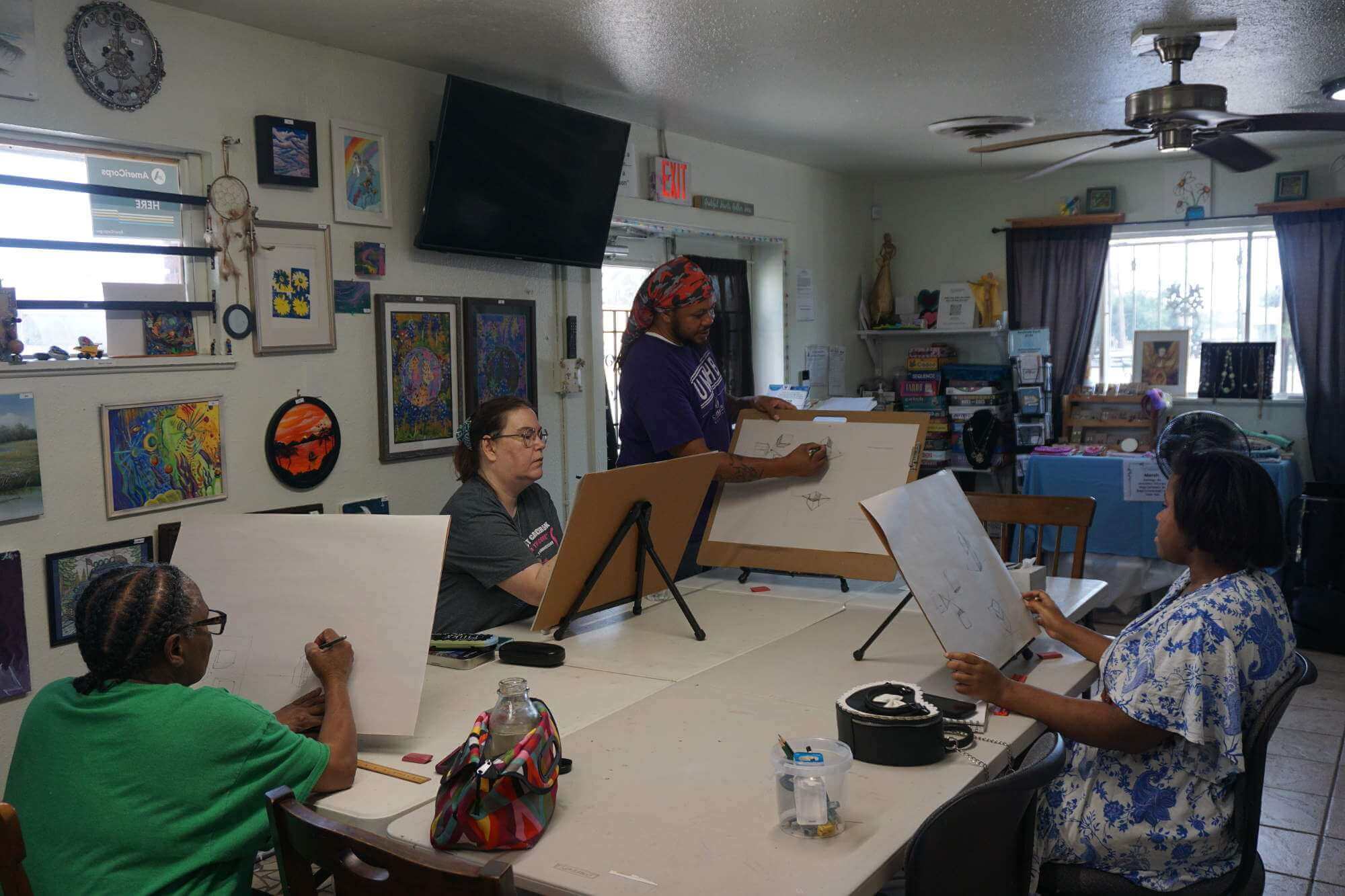 Killeen Creators drawing on easels around a table